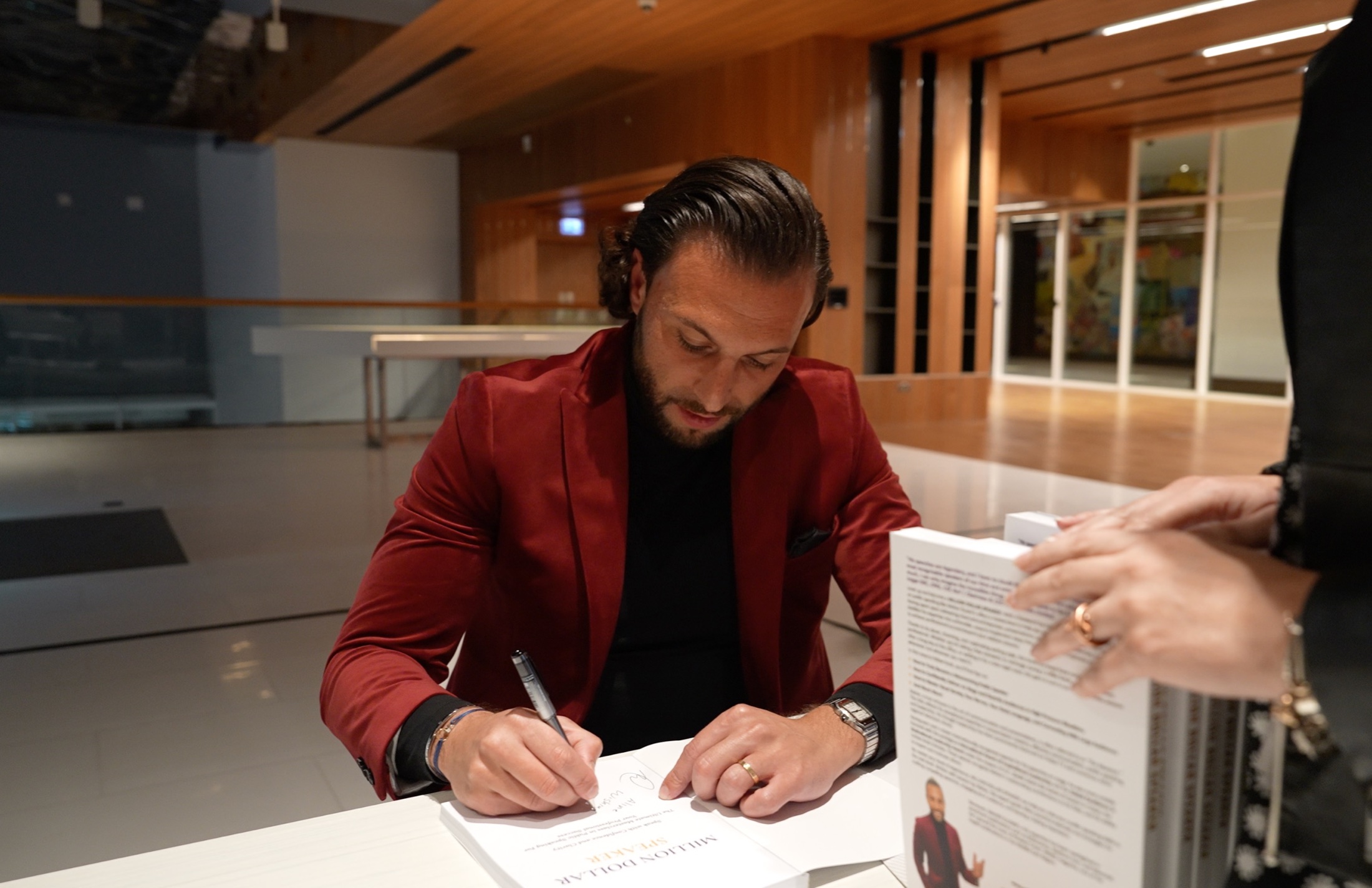 Maher Elusini autographing a copy of Million Dollar Speaker